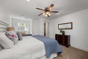 Carpeted bedroom with a ceiling fan and recessed lighting