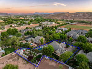 Aerial perspective of suburban area with property boundaries highlighted and a mountain backdrop