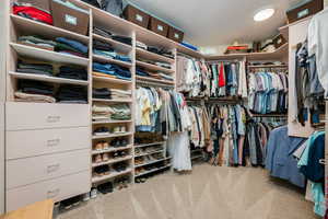 Walk in closet featuring light colored carpet
