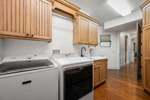 Laundry room with arched walkways, cabinet space, dark wood finished floors, and washer and dryer