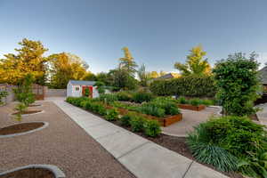 Surrounding community with a garden, a fenced backyard, and a storage shed