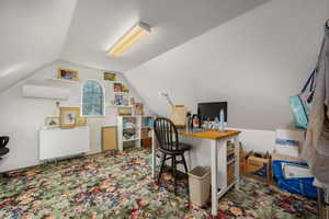 Carpeted office space featuring a wall mounted mini split