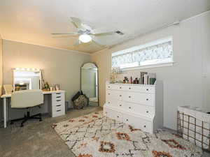 Bedroom with light colored carpet, a textured ceiling, wood walls, a ceiling fan, and a desk