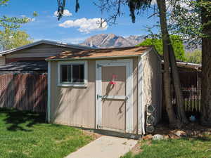 View of shed with a fenced backyard and a mountain view