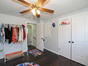 Bedroom featuring dark wood-type flooring, a closet, and ceiling fan
