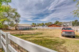 View of yard featuring an outdoor structure, an enclosed horse arena, and an exterior structure