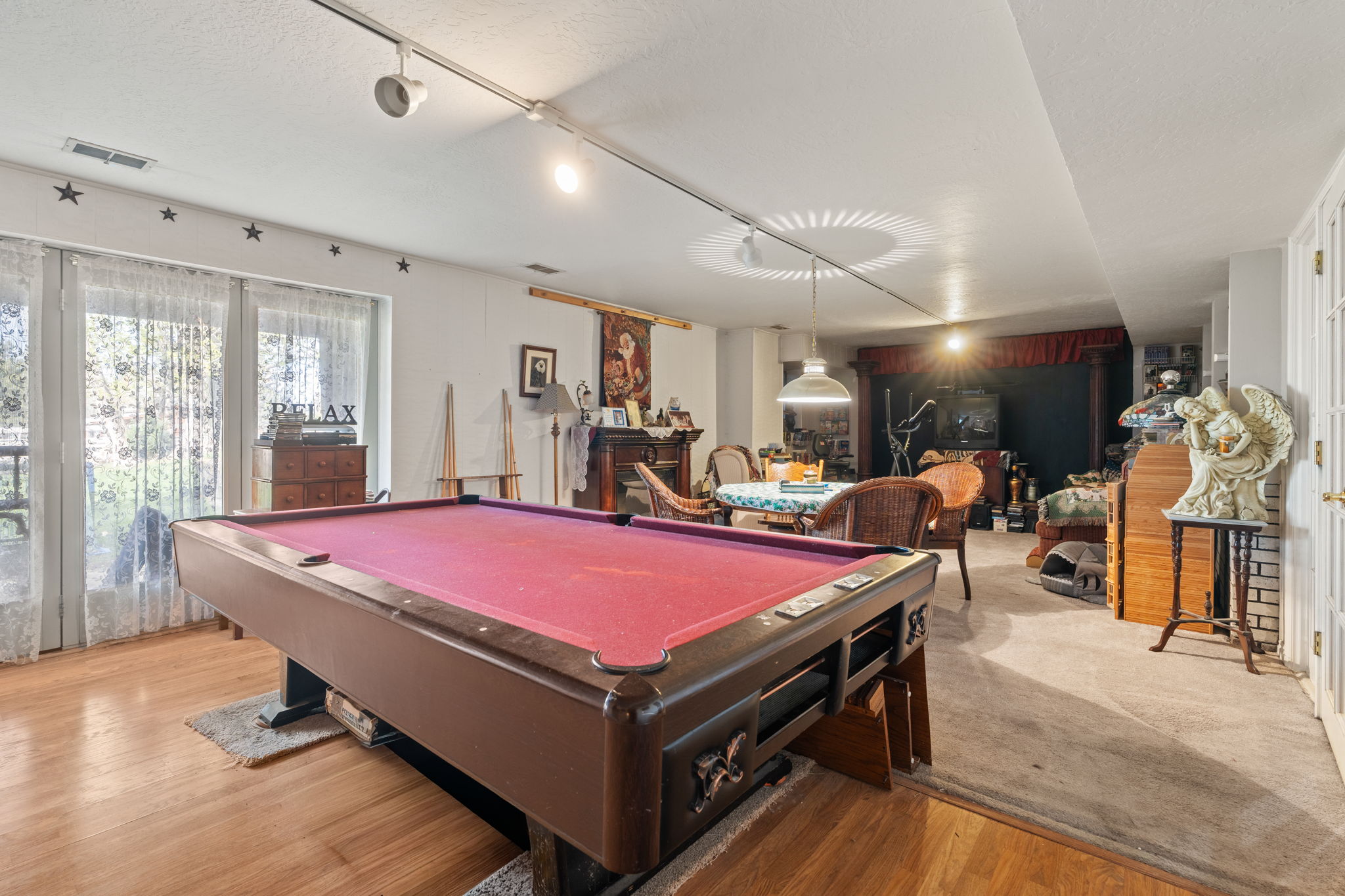 Game room featuring billiards, a textured ceiling, light wood-style floors, and rail lighting