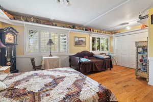 Bedroom with a closet, light wood-style floors, and a textured ceiling