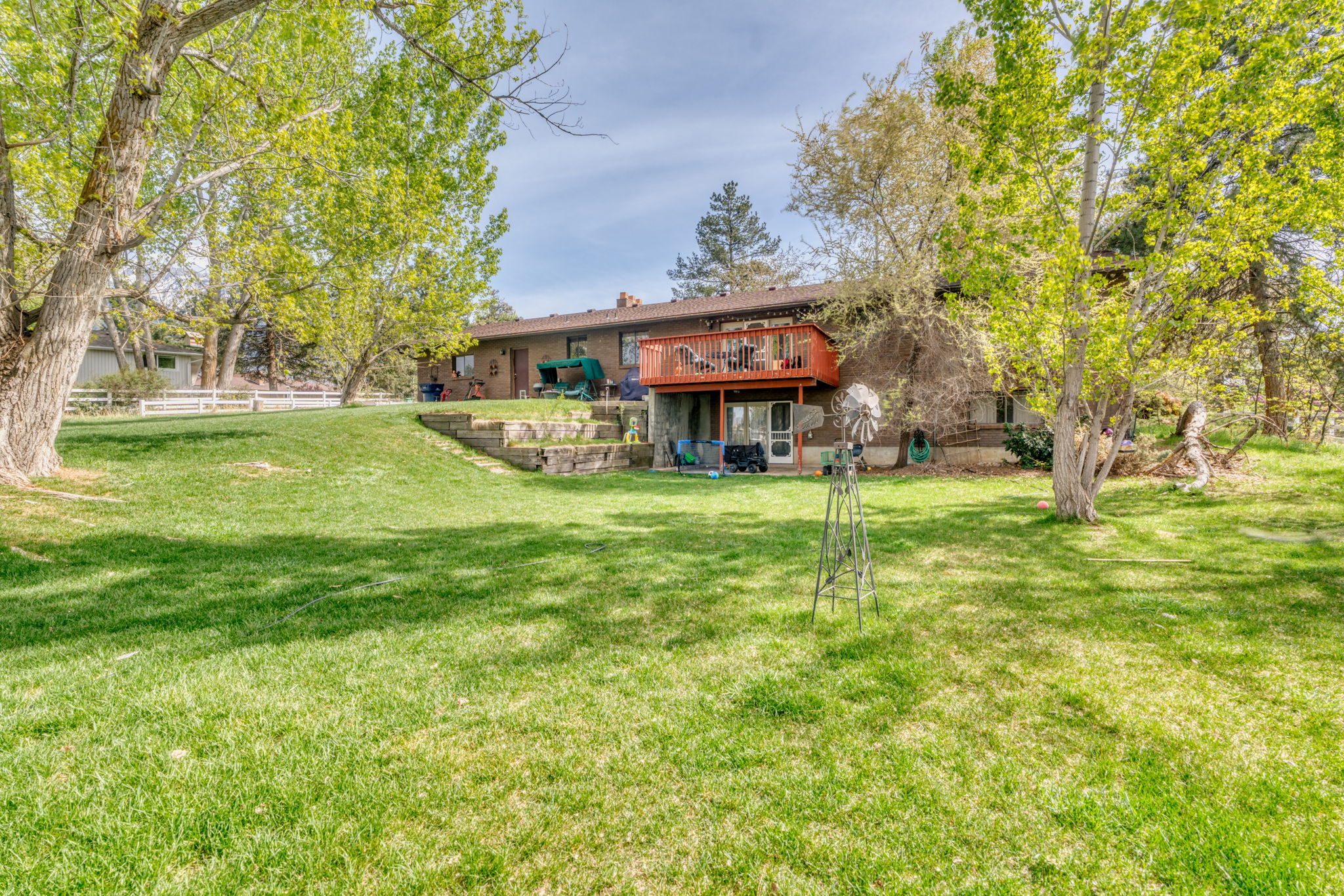 Back of property featuring a chimney, a deck, and brick siding