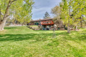 Back of property featuring a chimney, a deck, and brick siding