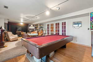 Recreation room with french doors, track lighting, wood finished floors, and billiards