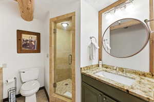 Full bathroom with a stall shower, vanity, and dark tile patterned flooring