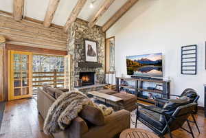 Living room with hardwood / wood-style floors, a fireplace, and vaulted ceiling