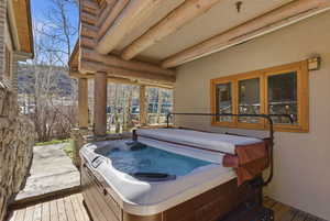 Deck with a hot tub and a mountain view