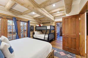 Bedroom featuring log walls, beamed ceiling, hardwood / wood-style floors, and recessed lighting