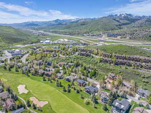 Aerial view of property and surrounding area with a mountainous background and nearby suburban area