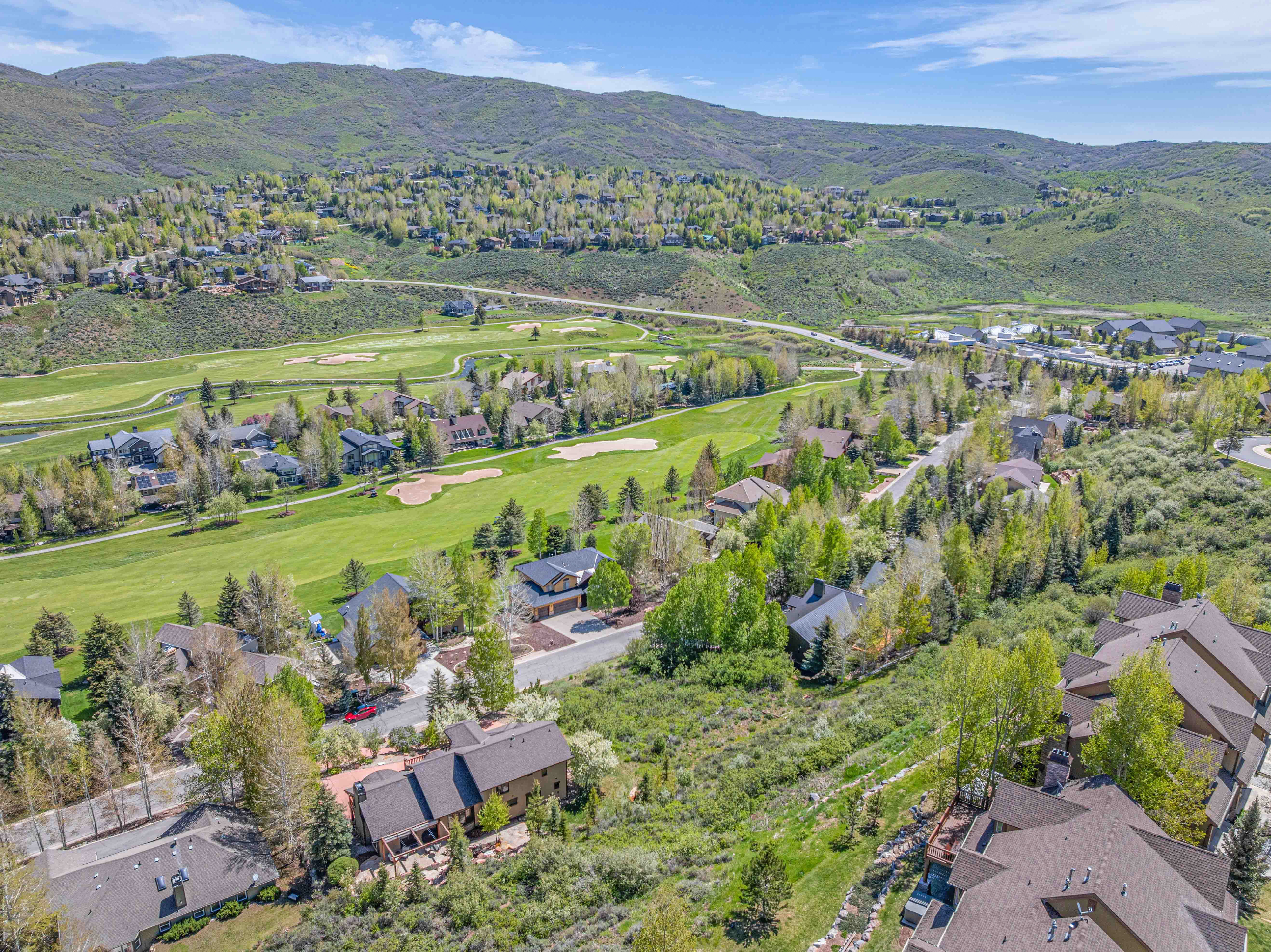 View of property location with mountains, nearby suburban area, and a golf course