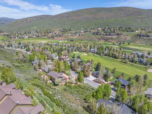 Aerial perspective of suburban area featuring a mountain backdrop and a golf course