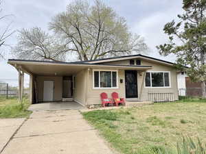 View of front of house with an attached carport, concrete driveway, and covered porch