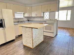 Kitchen with white appliances, dark wood finished floors, and decorative backsplash