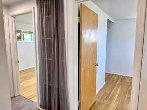 Corridor featuring light wood-style floors and baseboards