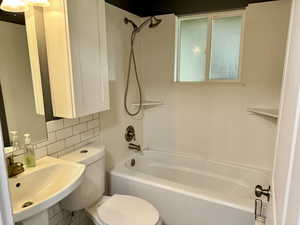 Bathroom featuring bathtub / shower combination and tasteful backsplash