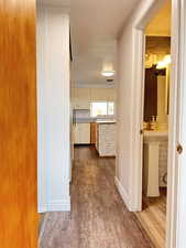 Corridor featuring dark wood-type flooring and baseboards