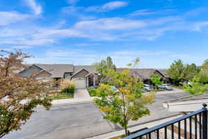 View of front of property featuring a garage, a residential view, and driveway