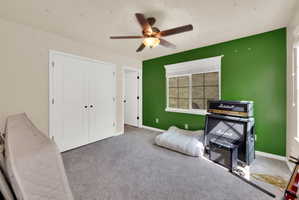 Bedroom with carpet floors, ceiling fan, and a closet