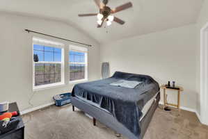 Bedroom featuring lofted ceiling, a ceiling fan, and light colored carpet