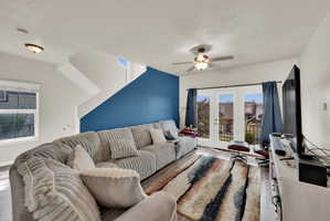 Living room featuring wood finished floors, a ceiling fan, and french doors