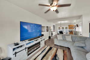 Living room featuring ceiling fan and dark wood-style floors