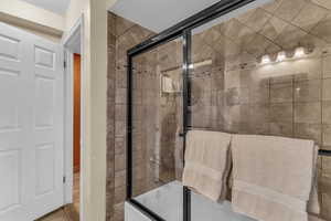 Full bathroom featuring shower / bath combination with glass door