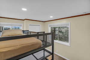 Carpeted bedroom featuring recessed lighting, multiple windows, and a closet