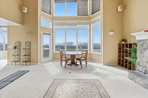 Dining area featuring a mountain view, carpet floors, and a stone fireplace