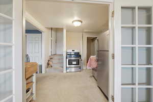 Kitchen featuring stainless steel appliances and light colored carpet