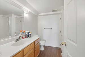 Bathroom featuring vanity, dark wood finished floors, a shower stall, and a textured ceiling