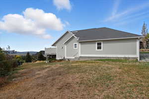 Rear view of property with a yard and roof with shingles