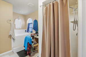 Bathroom featuring a shower stall and a bath