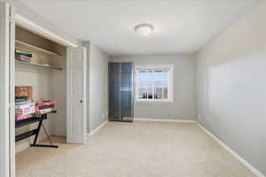 Unfurnished bedroom with light carpet and a closet