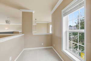 Hallway featuring crown molding and light carpet