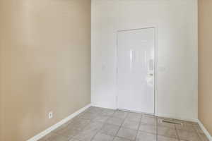 Entrance foyer with light tile patterned floors and baseboards