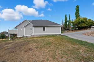 View of side of home featuring a yard and roof with shingles