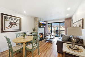 Dining room featuring a fireplace, light wood-style floors, and recessed lighting