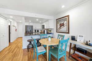 Dining space with light wood finished floors and recessed lighting