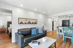 Living area with light wood-style flooring and recessed lighting