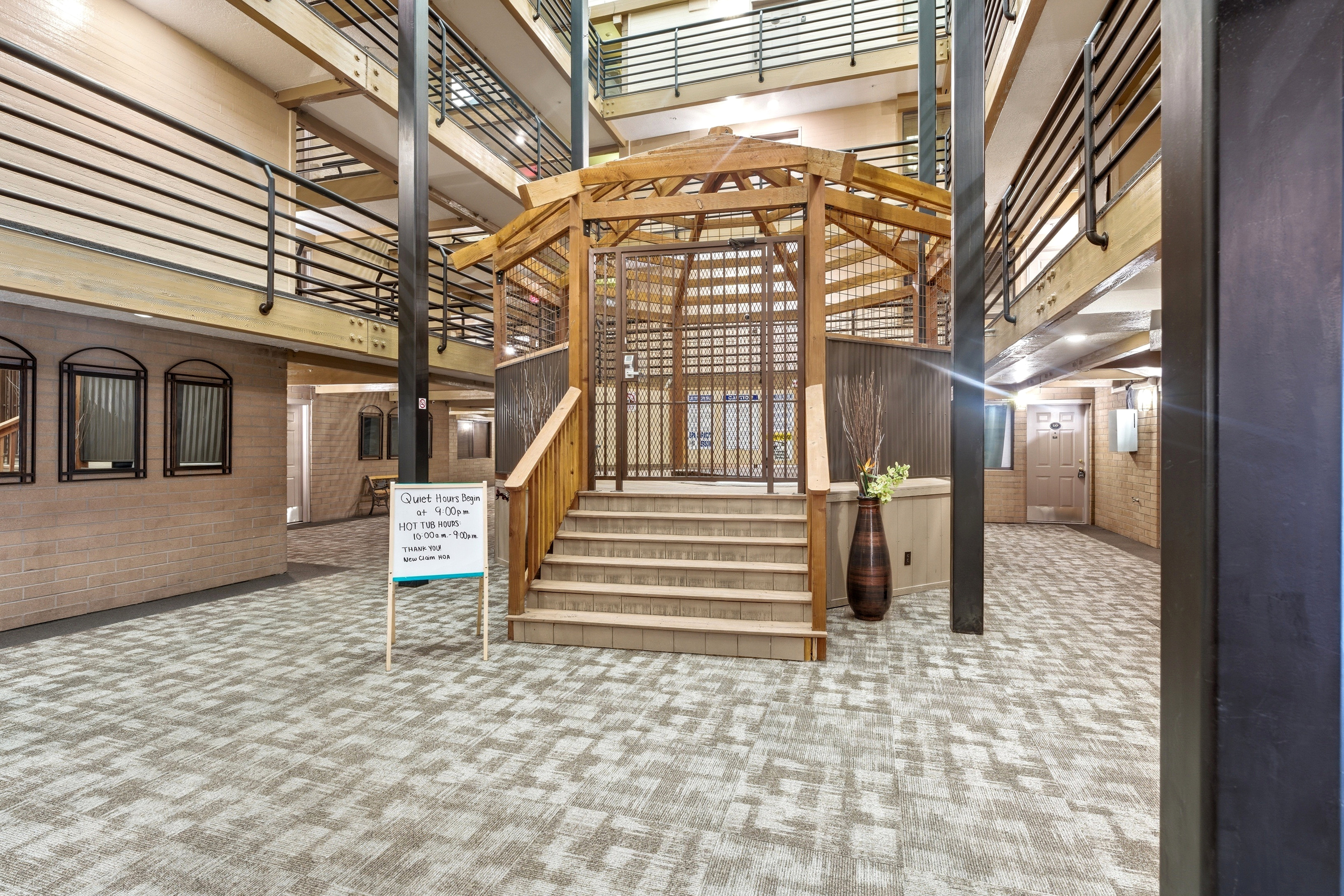 Stairs with a high ceiling, carpet floors, and brick wall