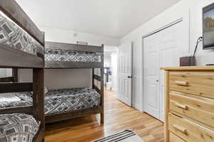 Bedroom with light wood-type flooring, a textured ceiling, and a closet