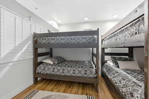Bedroom with light wood-style floors, recessed lighting, and a textured ceiling