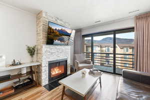 Living area featuring a fireplace, light wood-type flooring, and a textured ceiling